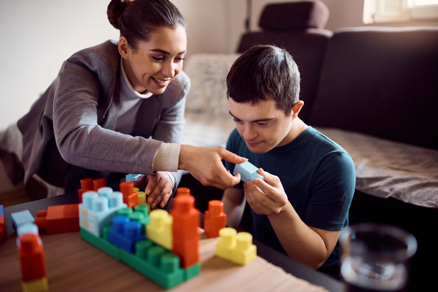 A woman playing a stimulating and educational game with a man with a disability.